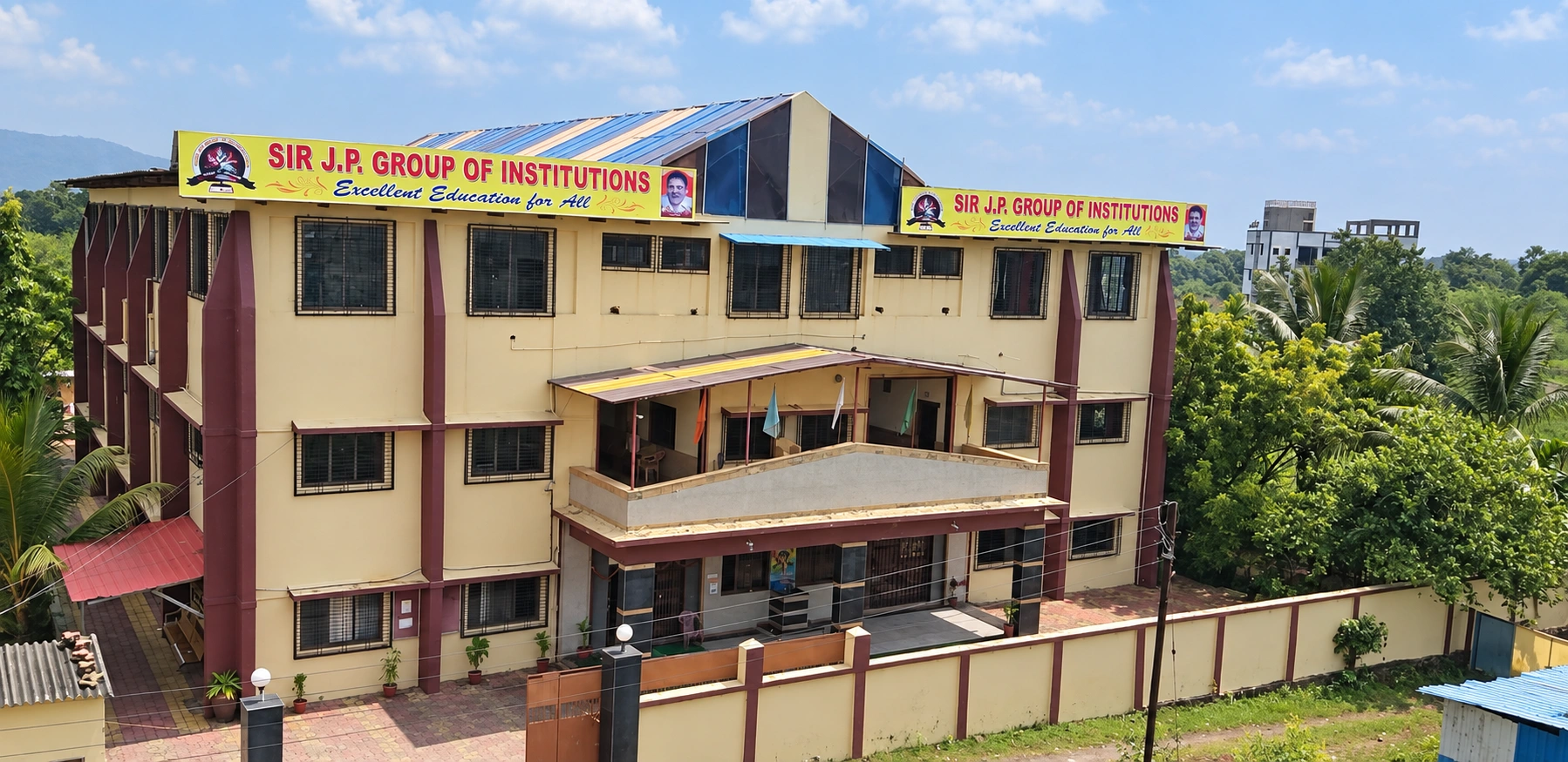 Street-facing building of Sir J. P. International School, Palghar, with SIR J.P. GROUP OF INSTITUTIONS signage and school boards visible